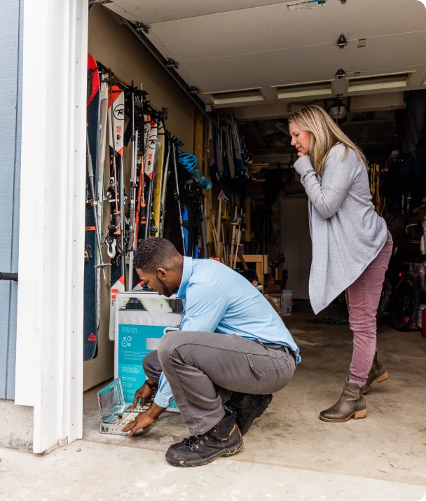 tech aidant une cliente dans son garage