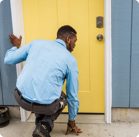 pest control technician in front of yellow door